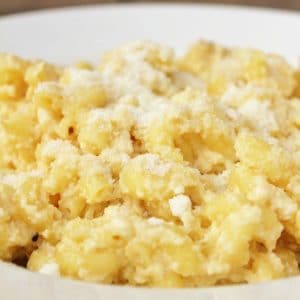 Bowl of Crockpot Mac and cheese with grated parmesan cheese on top.