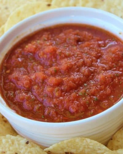 Bowl of restaurant style salsa with chips surrounding it