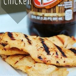 Three root beer chicken breasts on a plate with a liter of root beer in the background