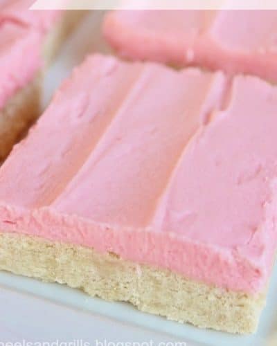 Up close photo of a plate of sugar cookie bars with pink frosting.
