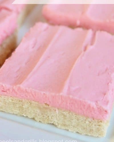 Up close photo of a plate of sugar cookie bars with pink frosting.