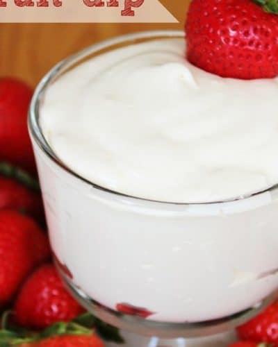 Bowl of fruit dip surrounded by whole strawberries.