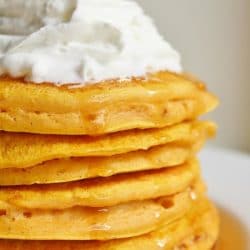 Stack of Pumpkin Pancakes with Whipped Cream on top.