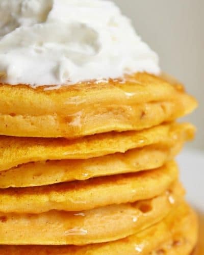 Stack of Pumpkin Pancakes with Whipped Cream on top.