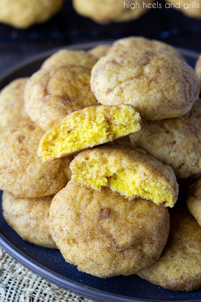 Plate of Pumpkin Snickerdoodles with the front cookie cut in half to show the inside.