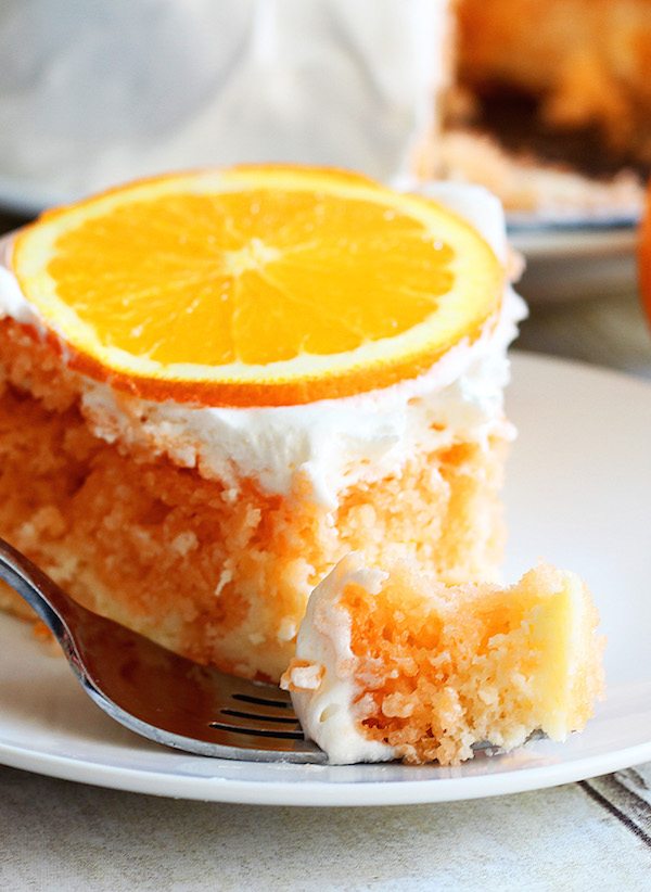 Skinny Orange Creamsicle Cake - a low calorie cake. Single slice of cake, with fork and cake piece in front.