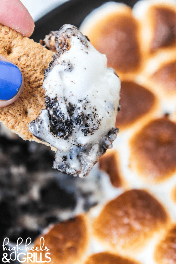 Cookies and Cream Smores Dip - Melted white chocolate chips, crushed Oreos, and toasted marshmallows. Dip with graham crackers to fully enjoy this amazing dessert! https://www.highheelsandgrills.com/cookies-and-cream-smores-dip/