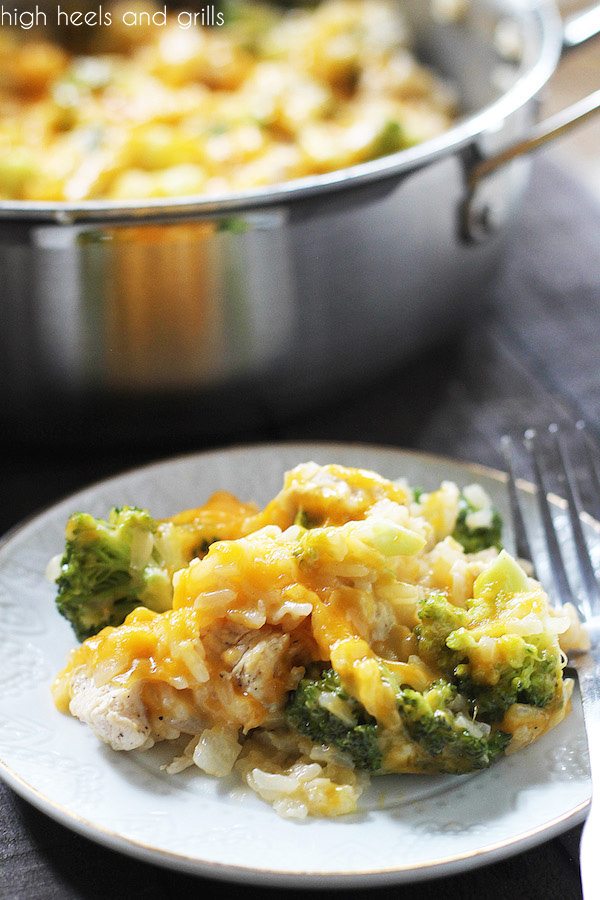Serving of One Pan Cheesy Chicken Broccoli Rice Casserole on a plate, with full pan in the background.