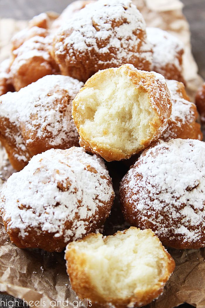 Pile of Biscuit Beignets with one cut in half to show the soft, fluffy inside.