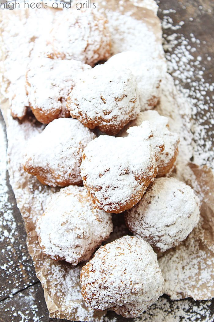 Big pile of biscuit beignets on a brown paper surface.