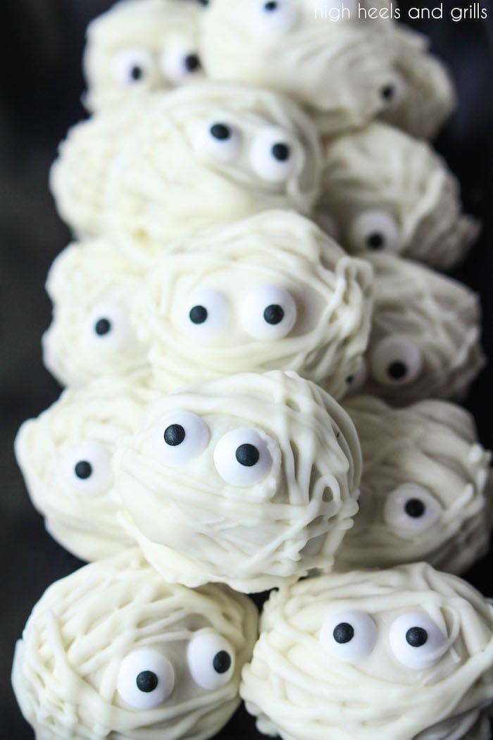 A platter of Easy Halloween Treat Donut Hole Mummies all lined up and two rows high.